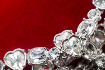 Heart shaped diamond on bracelet on red backround