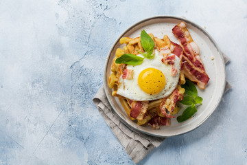 Cheese Waffles with fried bacon, egg and parmesan cheese with spices and basil for breakfast on light old concrete background. Top view.