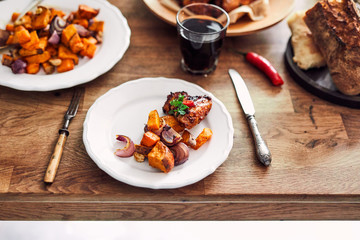 View of table served with traditional British Sunday roast dinner, featuring roasted chicken, squash and sweet potatoes
