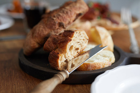 Closeup view of a plate of fresh bread served on dinner table on domestic kitchen