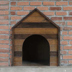 Wooden dog house in the brick wall