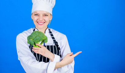 Woman chef hold broccoli pointing at copy space. Healthy vegetarian recipes. Amazing broccoli facts you should know. Healthy food. Dieting concept. Eat healthy. Girl hold vegetable. Organic nutrition