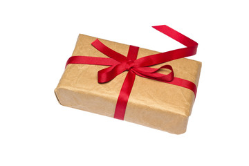 Gift box wrapped in brown recycled paper with red ribbon isolated on white background.