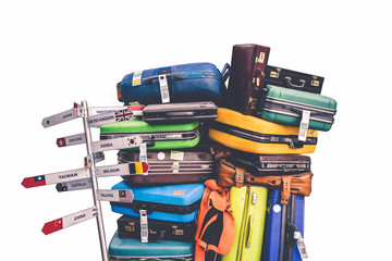 Travelling suitcases piled up with empty direction sign pole isolate on white