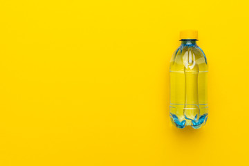 plastic water bottle with yellow cap on the yellow background with copy space
