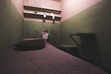 Old dirty prisoner's bedroom with toilet