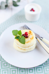 Homemade cheese pancakes on a white plate