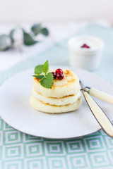 Homemade cheese pancakes on a white plate
