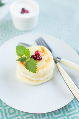 Homemade cheese pancakes on a white plate