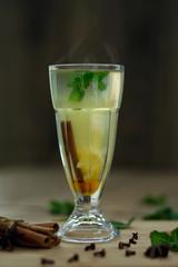 glass of hot vitamin tea on wooden table. winter hot seasonal drinks