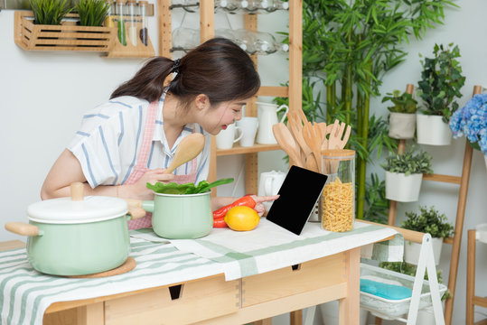 Closeup Of Human Hands Cooking In Kitchen Using Touch Pad. Healthy Meal, Vegetarian Food And Lifestyle Concept