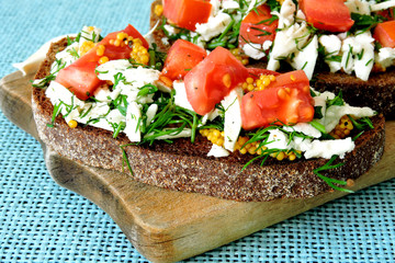 Toasts with white cheese and herbs with garlic on a small wooden board. Open sandwiches with selenium and cottage cheese. Garlic toast with grated mozzarella cheese and greens. 