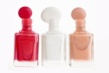 Nail color bottles spilled on white background
