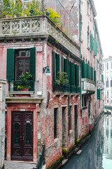 Naklejka premium Venice / Italy 19 february 2019 :traditional window with flowers in venice street,the photo is showing the road to the light through darkness