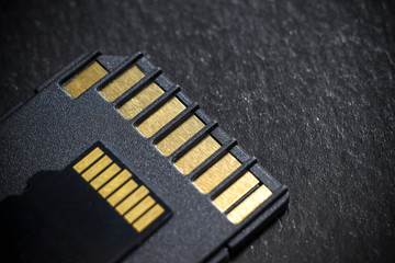 Micro SD card and adapter on black background.