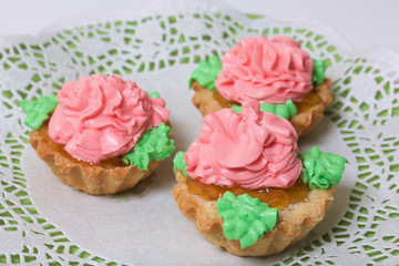 Basket cakes decorated with cream of different colors. Stuffing from jam.