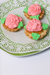 Basket cakes decorated with cream of different colors. Stuffing from jam.