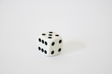 Primo piano di un dado bianco, su sfondo bianco, giochi di società