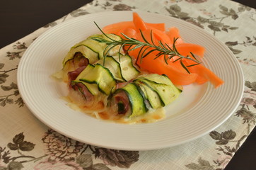 Involtini di zucchine ripiene di speck cotto e scamorza affumicata con riccioli di carote. 