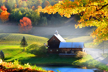 Old barn in Vermont rural side surrounded by fall foliage - obrazy, fototapety, plakaty