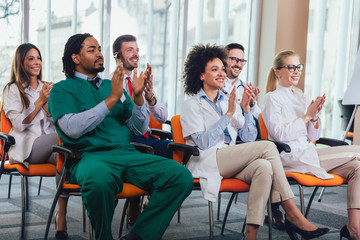 Group of happy doctors on seminar in lecture hall at hospital