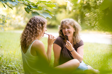Mother with daughter having fun as they bite chocolate