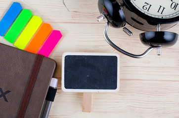 template background with wooden signage for text, alarm clock, sticky paper and diary  on desk