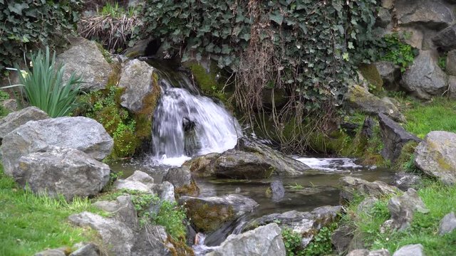 Flowing water stream, water drops and reflection