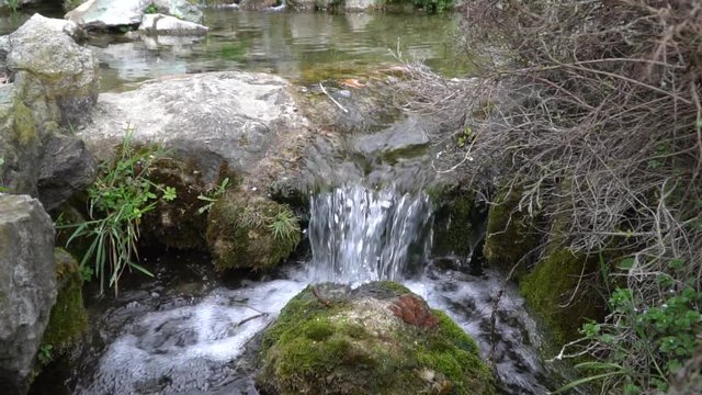 Slow motion Flowing water stream, water drops and reflection