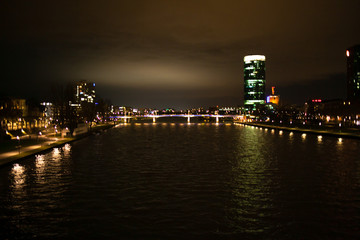 Fototapeta na wymiar Bright view on the night city, river and skyscraper.