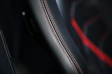 Red stitching on black leather car seat