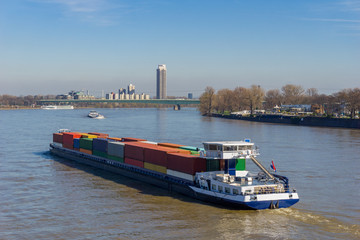 Riesiges Containerschiff mit vielen großen Containern fährt durch den Rhein in Köln. - 256660137