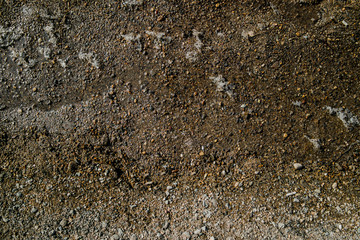 Detail of surface texture with small pebble rock on dirty ground. Wet gravel texture. Natural...