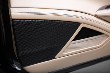 Close up of speaker in cream leather car interior