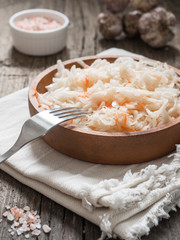 Sauerkraut. Fermented cabbage in a brown clay plate on a wooden table. Healthy vegetarian food and best natural probiotic