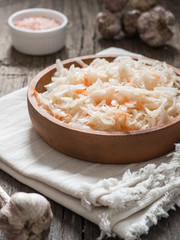Sauerkraut. Fermented cabbage in a brown clay plate on a wooden table. Healthy vegetarian food and best natural probiotic