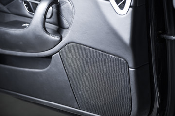 Close up of speaker in black leather car interior