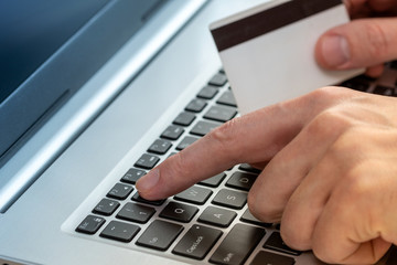 Fototapeta na wymiar Hands holding credit card and using laptop