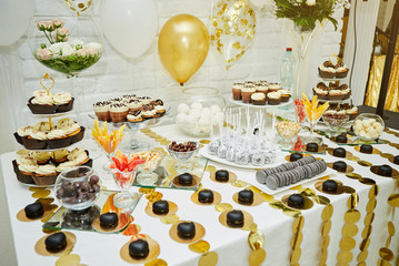 candy bar decorated by delicious sweet buffet with cupcakes and other desserts/candies,happy birthday concept