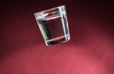 falling small glasses and spilling water on a red background