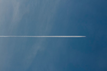 Trace of an airplane that crosses the blue sky