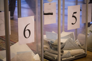 Illustrative image of the election in a democratic society. Elections in Ukraine. The process of voting at a polling station. Bulletins lie in the ballot boxes.