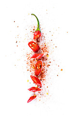 Red chili pepper, cut into pieces and isolated on white background. Hot spice, red chili pepper and chili powder.  - obrazy, fototapety, plakaty