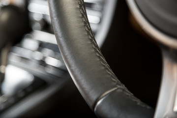 Detail shot of leather car steering wheel with stitching