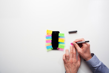 Businessman putting post it notes onto a smart phone