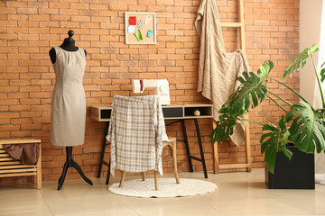 Stylish tailor's workplace in interior of workshop