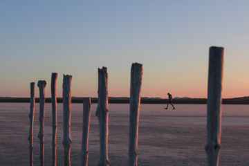 Man Walking through salt pan beautiful sunset