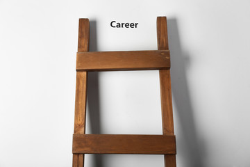 Wooden ladder near light wall. Concept of career growth