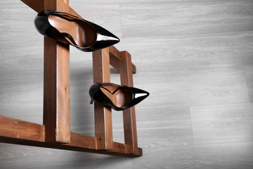 Female shoes on wooden ladder. Concept of career failure