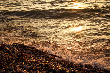 Golden, Fiery sunset on the Black Sea, on the beach. Coast, stones, waves, sun, beautiful sky, clouds. August, Batumi, Georgia. Water, ease, game.